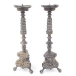Pair of pewter pricket alter sticks, raised on trefoil bases cast with figural masked panels, 13"