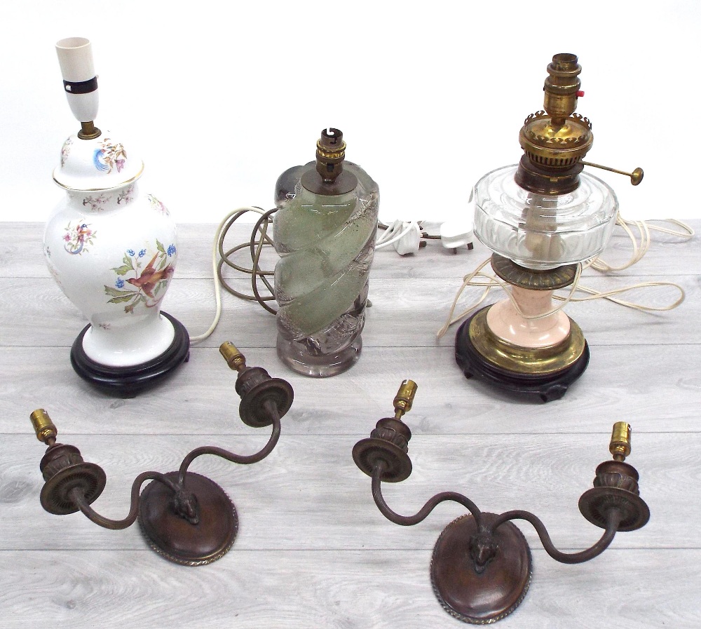 Three table lamps; a converted brass and porcelain oil lamp, one bubble inclusion glass and one