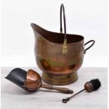 Copper helmet shape coal scuttle, 15" high; together with a copper shovel with turned wooden