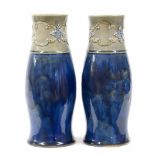Matched pair of Royal Doulton stoneware glazed pottery vases, of bottle form with stylised scroll