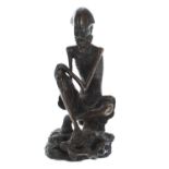 Japanese bronze figure of a skeletal man, cast seated upon a naturalistic base, 5" high