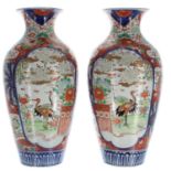 Pair of Japanese Imari vases, decorated in a typical palette with panels of garden scenes with