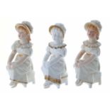 Royal Worcester - three similar porcelain figures each modelled as a girl seated on a chair, each