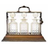 Early 20th century silver plated three bottle tantalus by Daniel & Arter  the lock plate release