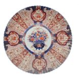 Large 19th century Japanese fluted Imari charger, decorated centrally with a vase of flowers