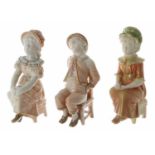 Royal Worcester - three blush ivory porcelain figures of seated children; a boy asleep and two