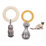 Two cat themed teething ring/rattles, one silver, one plated; together with a Kenart enamelled