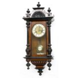 Vienna walnut two-train wall clock, with ebonised pediment and pillared case, 31" high (pendulum and