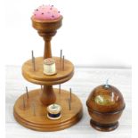 Treen ball wool winder, 4" high; together with a tiered cotton reel holder with pin cushion, 11"