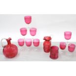 Set of nine Victorian cranberry wine glasses, cranberry glass decanter, jug and a cylindrical jar (