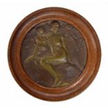 Art Nouveau circular bronze plaque in an oak frame, cast in low relief with a putto and maiden, 8"