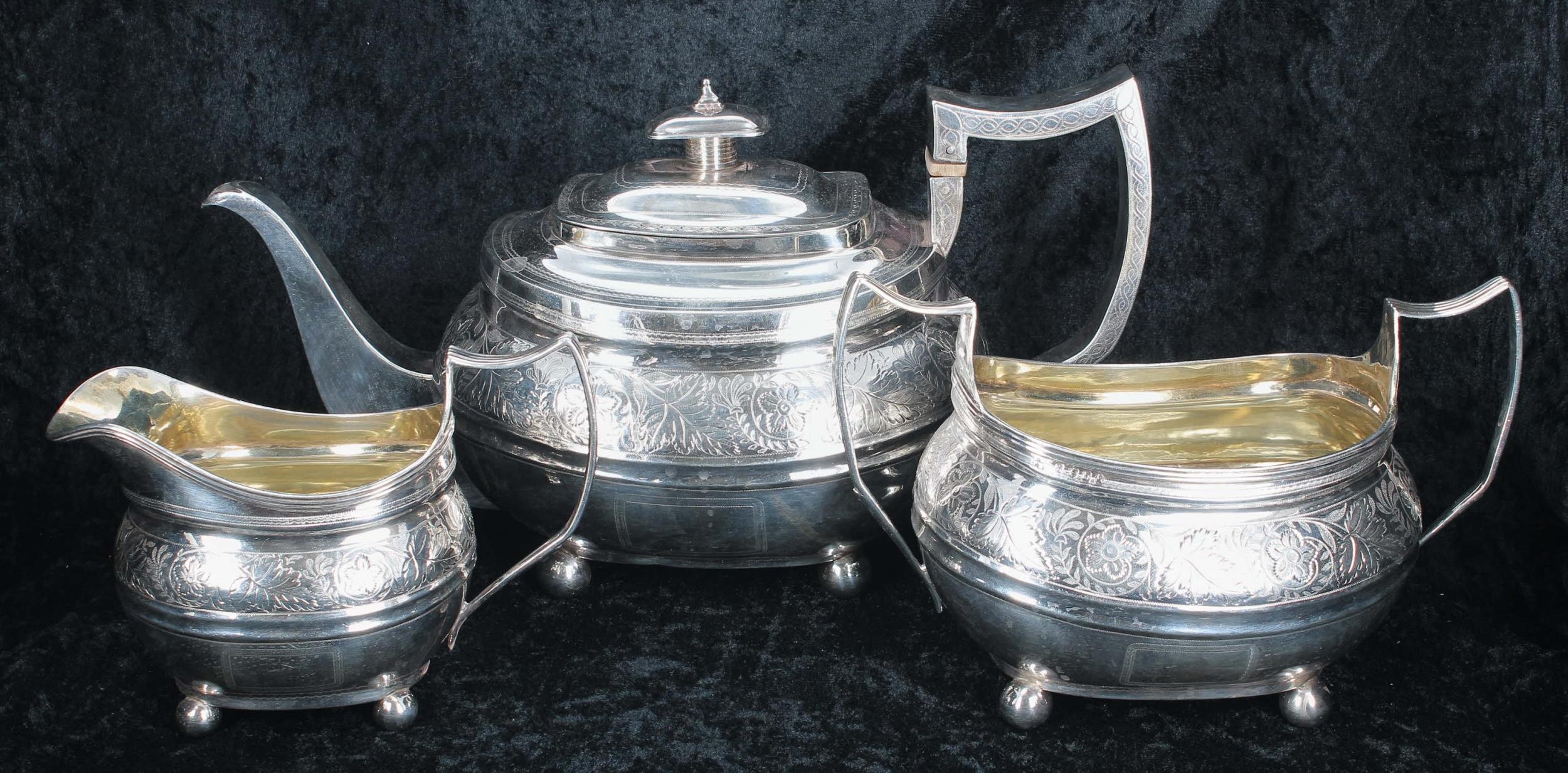 George III three piece boat shaped silver tea set, comprising teapot 6" high, twin-handled sucrier