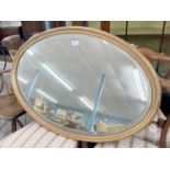 Early 20th century oval gilded and gesso wall mirror with a reeded frame and inset with a bevelled