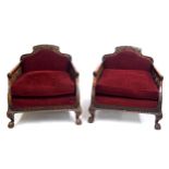 Pair of 1920s bergere armchairs, the backs with carved putti faces, wings and flowers, over