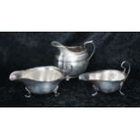 Two similar silver sauce boats, both with card cut rims raised on three feet, makers Synyer &