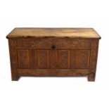 18th century carved oak coffer, the hinged pleated top over four panelled foliate and floral