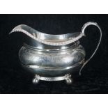 George III silver gilt cream jug, decorated with foliate and floral border, raised upon four ball