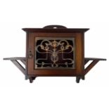 Art Nouveau mahogany wall cabinet, the panelled door with stylised pierced brass grille, flanked