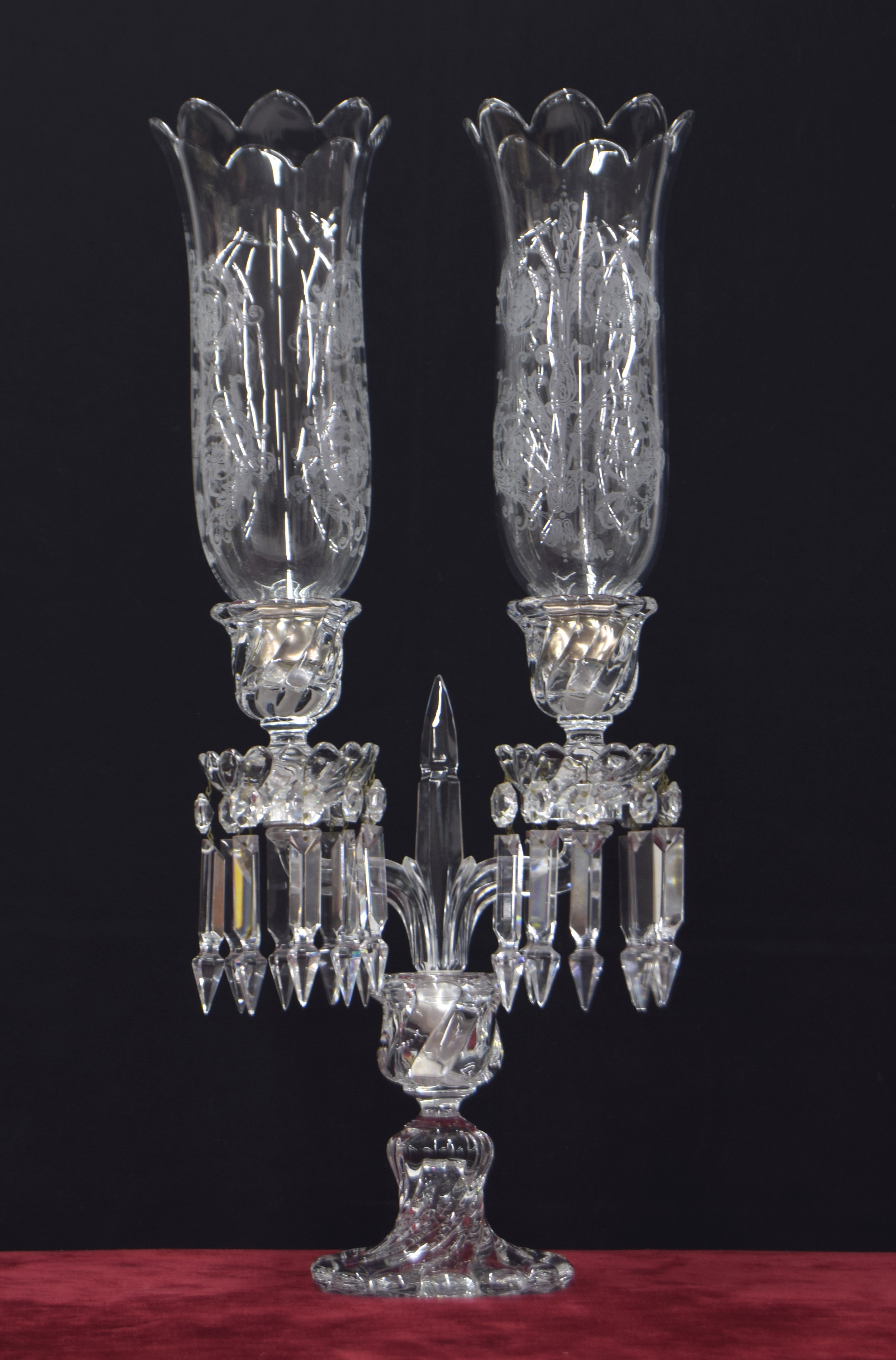 Baccarat twin-branch candelabrum with etched storm shades, the sconces with facetted drops drops,