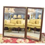 Pair of mahogany effect brass bound bevelled glass wall mirrors, 44" x 33.5"