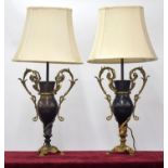 Pair of patinated and gilt metal lamps by Bradley Hubbard, of twin-handled urn form with modern silk