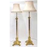 Matched pair of Corinthian column telescopic brass standard lamps with paw feet, with silk shades,