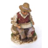 Pottery figurine of a seated busker playing a concertina on a park bench, 8.5" high