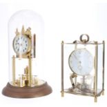 Brass torsion mantel clock, the 2.75" white dial over a disc pendulum, under a glass dome and upon a