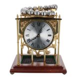 Good reproduction brass novelty clock, the movement with platform escapement powered by ball