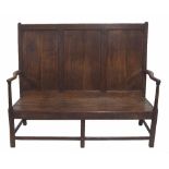 18th century oak settle, the triple panelled back over curving tapering arms and triple planked