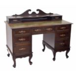 Early 20th century mahogany desk, the raised back over inset tooled leather writing service, on twin