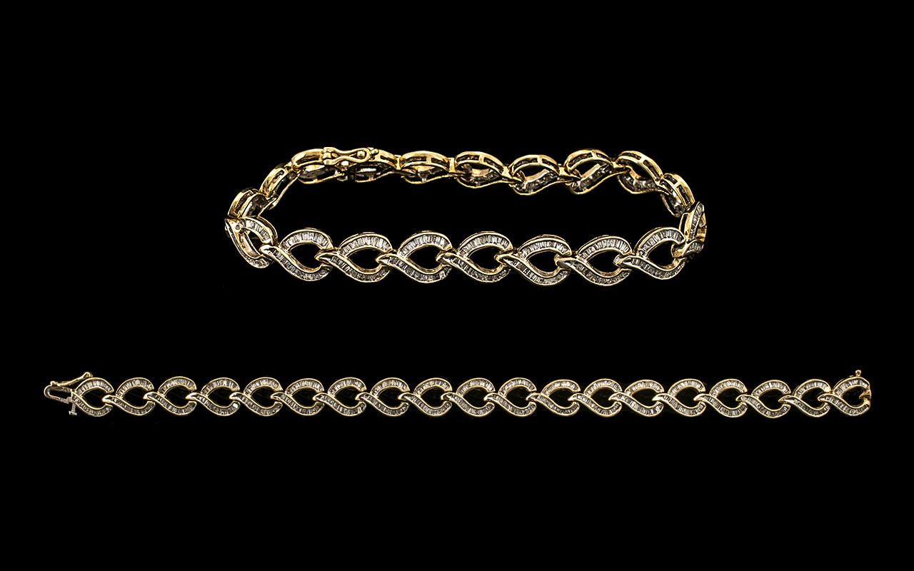 Ladies - Attractive 10ct Gold Baguette Diamond Set Tennis Bracelet of Contemporary Design. Marked