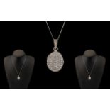 A Contemporary and Attractive 9ct White Gold CZ Set Hinged Locket with Attached 9ct Gold Chain.