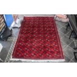 A Genuine Excellent Quality Persian Turkmen Carpet/Rug decorated in a Bukhari design on red ground.