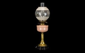 Victorian Oil Lamp with Pink Glass Font, Supported on a Brass Reeded Column on a Black Pottery Base,