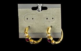 A Pair of Hoop Earrings Set with faceted red and white stones stamped 18k. 5.6 grams.