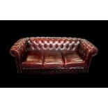 An Ox Blood Leather Chesterfield Sofa. With button back and arms.