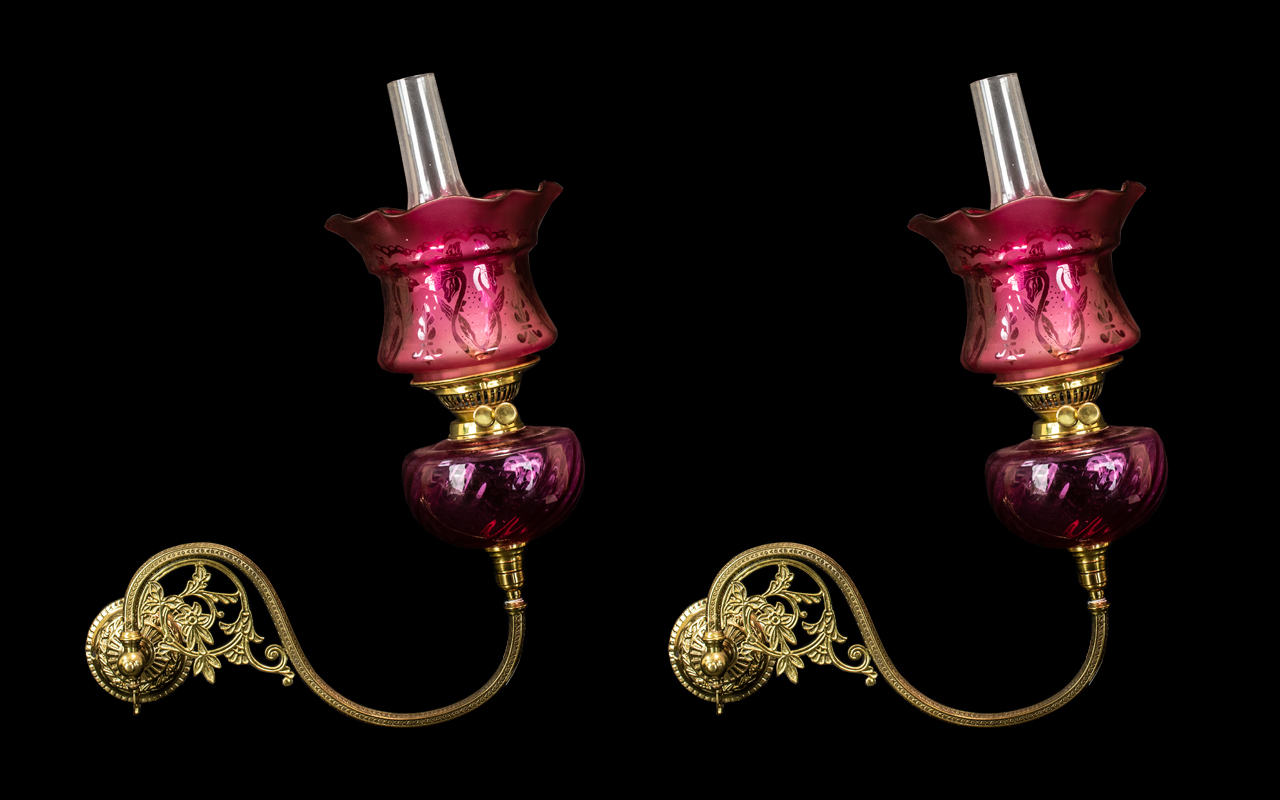 A Pair of Victorian Brass Gaselier Arm Wall Fitments converted to Oil Lamps with a ruby glass font