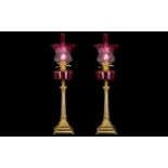 A Pair of Mid 20thC Oil Lamps with a ruby glass font and matching shade and funnel.