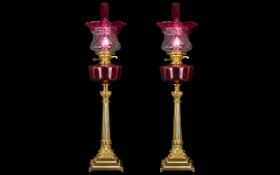 A Pair of Mid 20thC Oil Lamps with a ruby glass font and matching shade and funnel.
