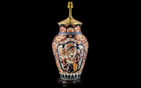 A Japanese Imari Table Lamp of moulded fluted form with brass mounts raised on a wooden circular