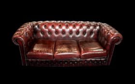 An Ox Blood Leather Chesterfield Sofa. With button back and arms. Measures approx 185 cms wide, 85