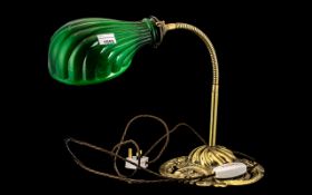 A Brass Mounted Expandable Arm student lamp with a green glass shade and a fancy brass cast base.