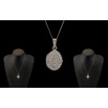 A Contemporary and Attractive 9ct White Gold CZ Set Hinged Locket with Attached 9ct Gold Chain. Both