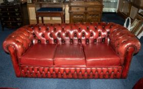 An Ox Blood Leather Chesterfield Sofa. With button back and arms. Measures approx 185 cms wide, 85