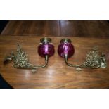 A Pair of Ruby Red Wall Bracket Oil Lamps with Ruby Font and brass filigree and Funnel.