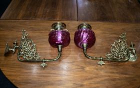 A Pair of Ruby Red Wall Bracket Oil Lamps with Ruby Font and brass filigree and Funnel.