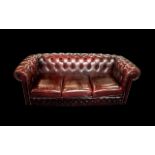 An Ox Blood Leather Chesterfield Sofa. With button back and arms. Measures approx 185 cms wide, 85