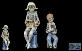 Nao by Lladro Pair of Hand Painted Porcelain Figures. Comprises 1/ Young Boy Harlequin Holding a