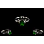 Russian Diopside and Diamond Ring, an oval cut Russian diopside of 1.75cts, having the dark